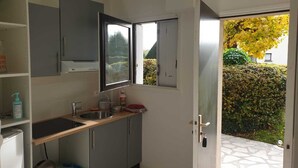 Cucina compatta con finestra, lavello e un piccolo piano di lavoro.