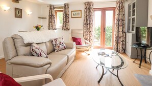A living room with a sofa, a glass coffee table, and a television. - Top House (Settle)
