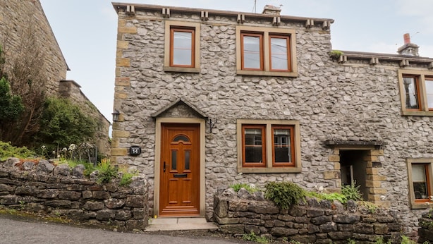 A stone building with a wooden front door, two windows, and a chimney. - Top House (Settle)