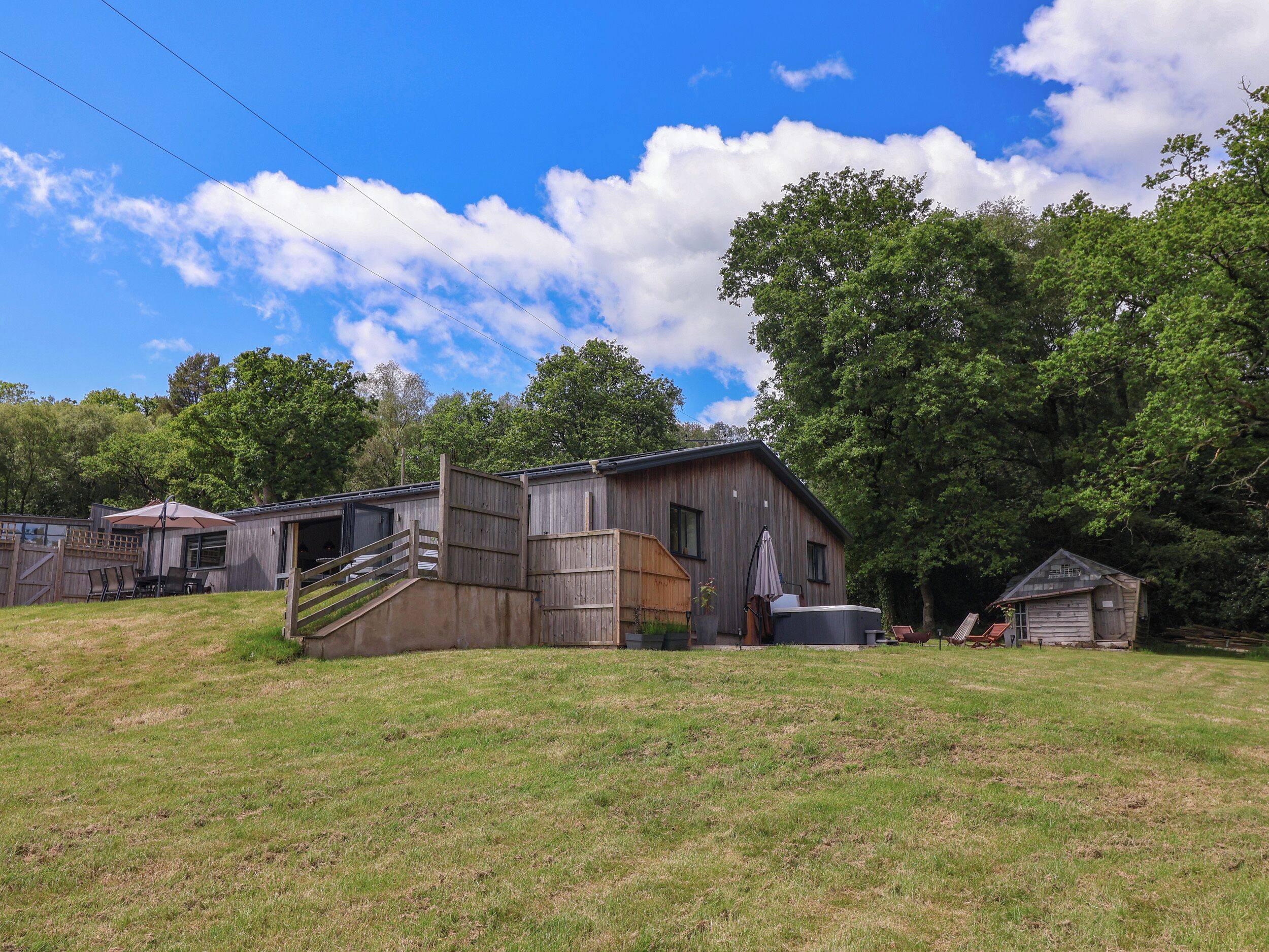 A rustic wooden barn with a covered porch and a small shed.