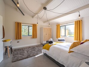 Een moderne slaapkamer met een bed, bureau en garderobe.