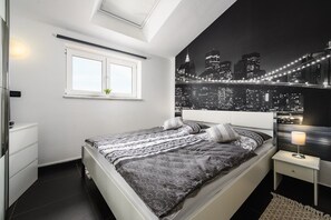 A bedroom with a bed, a nightstand, a window, and a cityscape mural on the wall. - Villa Elisa with pool in Istria (Rojci)