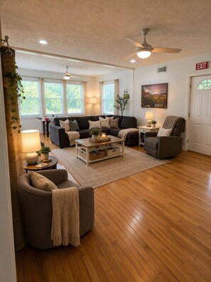A spacious living room with a sofa set, a coffee table, and a fireplace. - Wears Valley Farmhouse with Wonderful Views, hot tub and firepit (Sevierville)