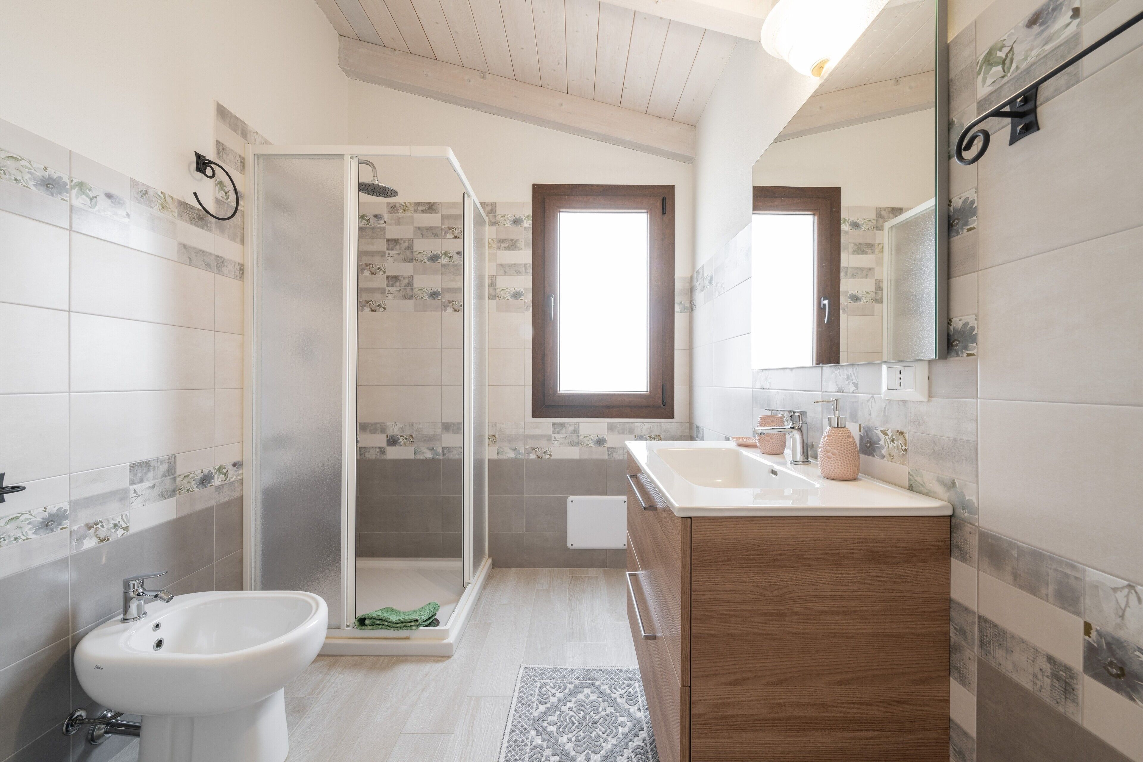 Un baño moderno con ducha, lavabo y tocador.