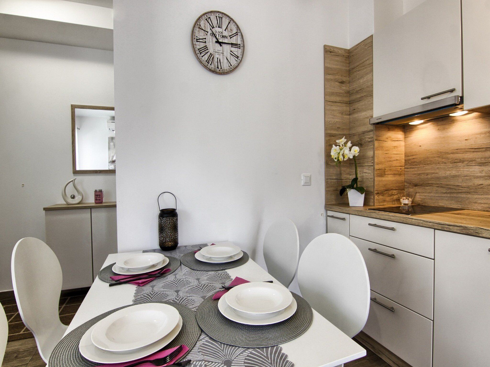 A modern kitchen with white cabinets, a wooden countertop, and a built-in stove.