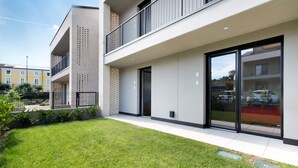 A modern building with a flat roof, large windows, and a well-maintained lawn.