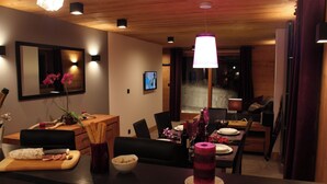 A modern dining area with a wooden table, chairs, and a bar counter.