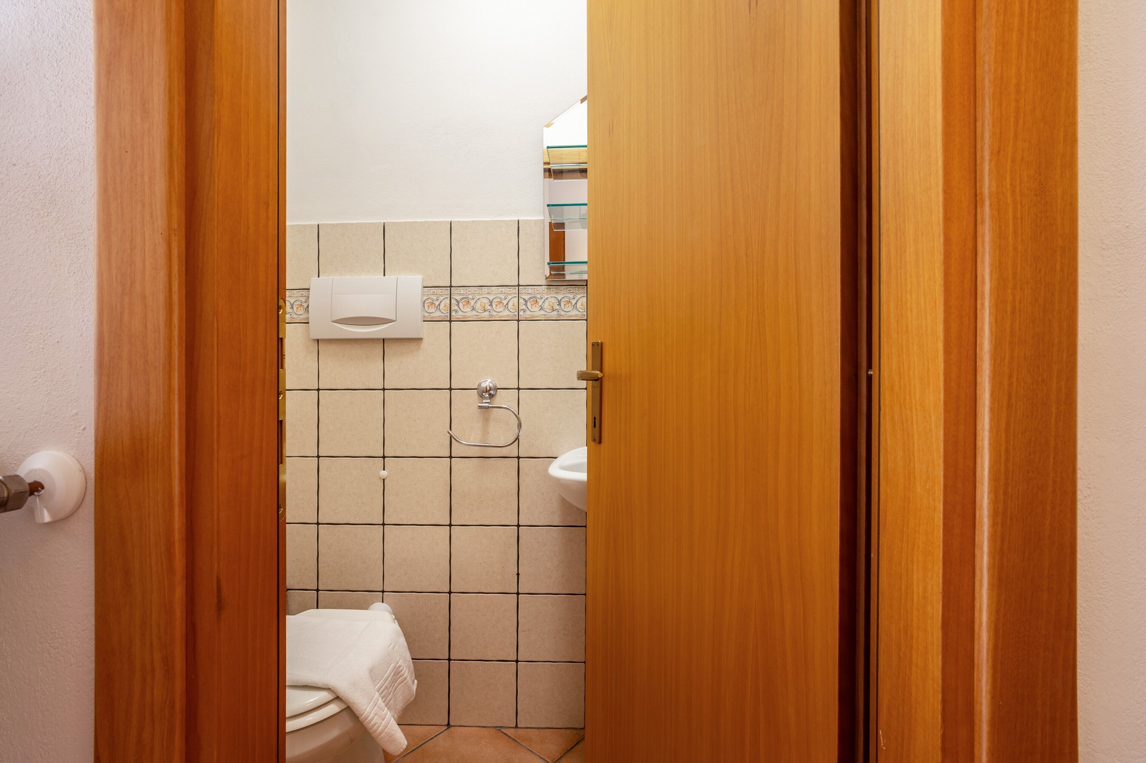 Ein Badezimmer mit Toilette, Waschbecken und Handtuchhalter.