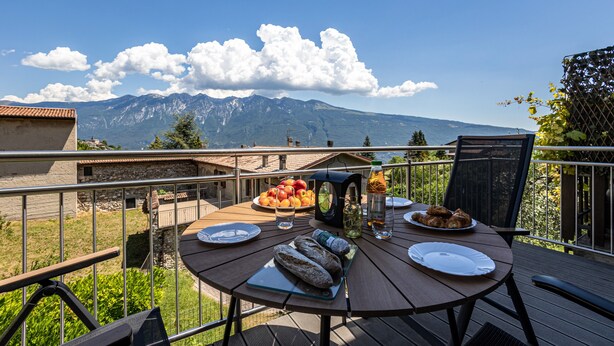 Een eettafel met eten en drinken, een uitzicht op de bergen en een heldere lucht.