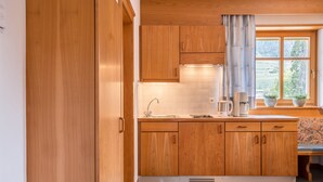 Una cocina con armarios de madera, un ventanal con vistas y un lavamanos.