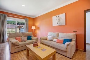 A living room with two sofas, a coffee table, a lamp, and a horse painting on the wall.