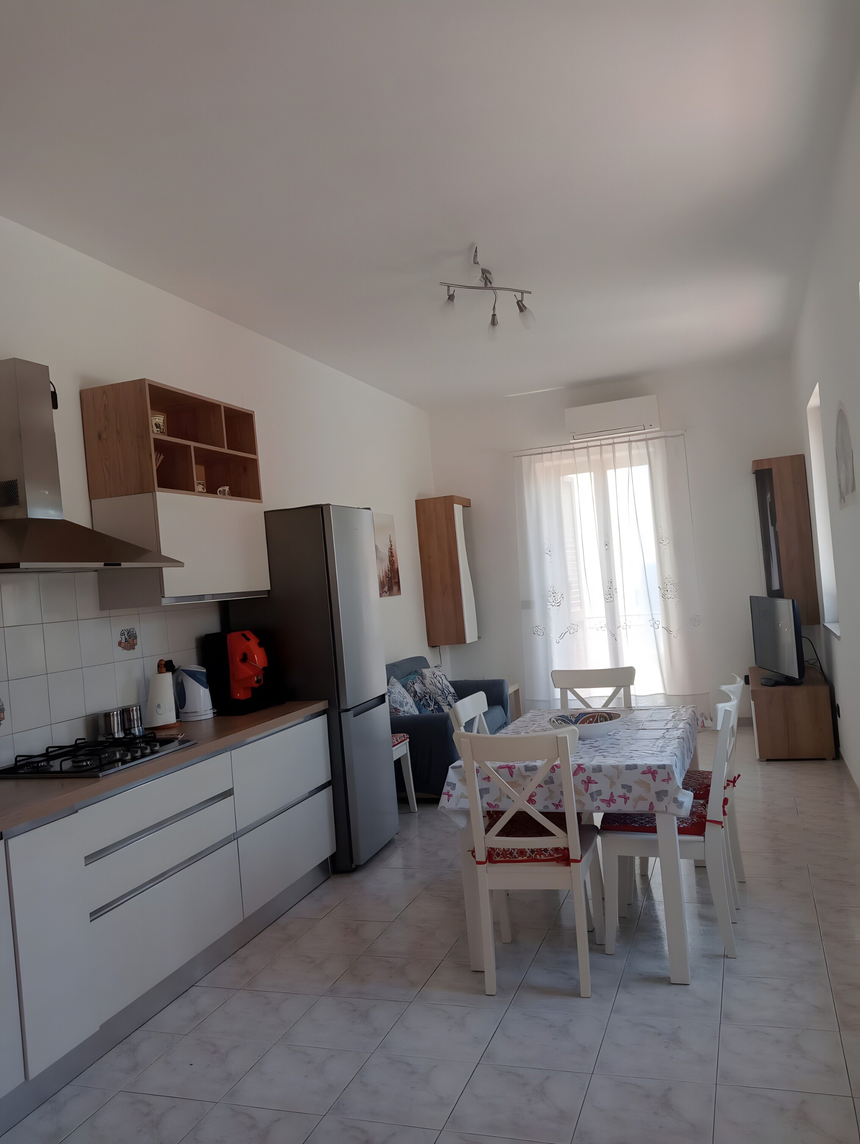 A compact kitchen with a refrigerator, stove, and wooden cabinets.