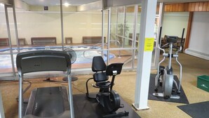 A gym with a treadmill, stationary bike, and exercise equipment.