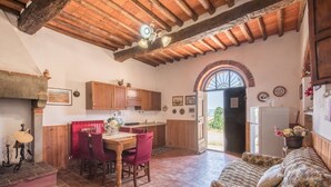 Une cuisine rustique avec des meubles de rangement en bois, une table à manger avec des chaises et un canapé.
