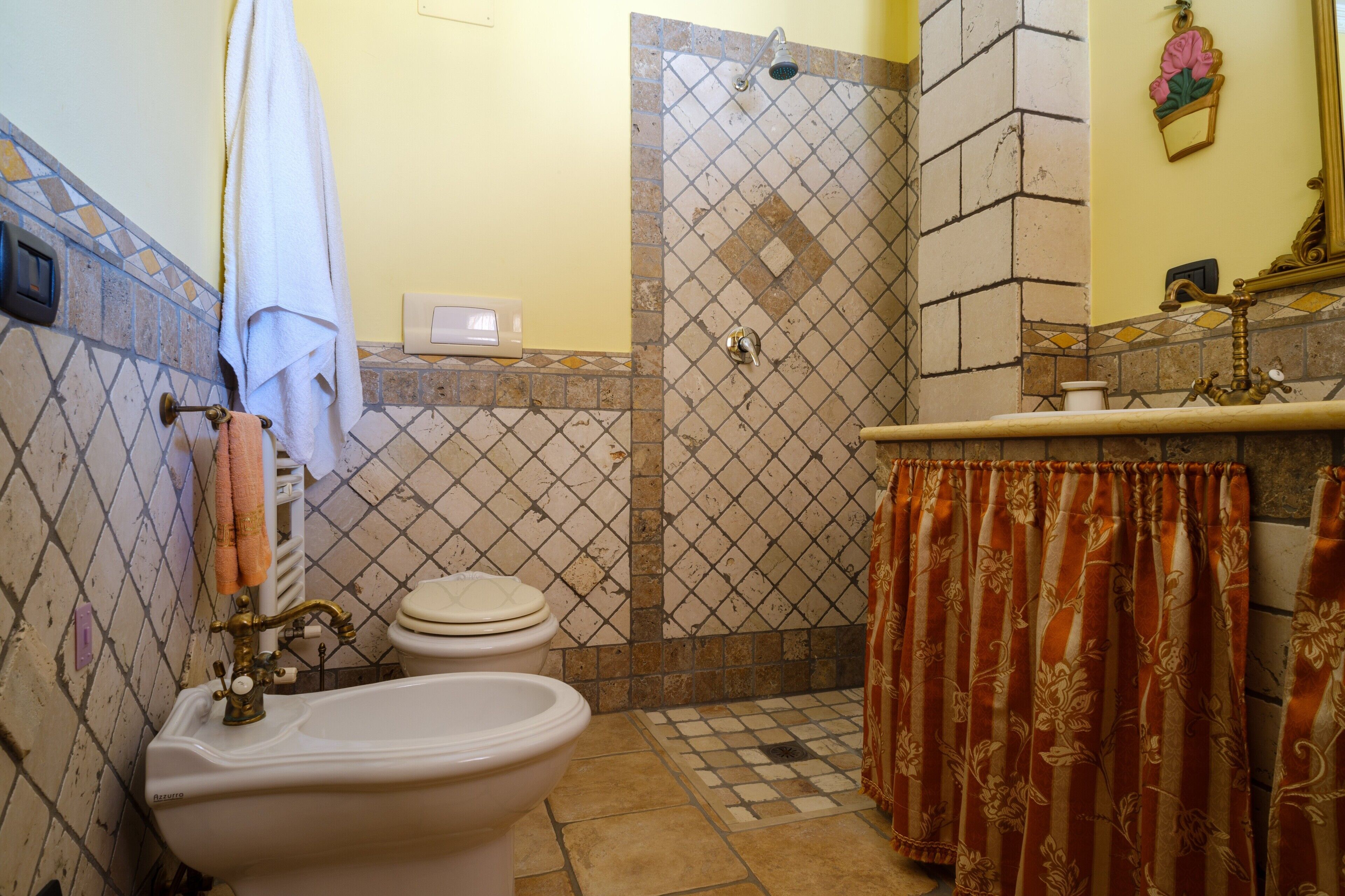Une salle de bain équipée de toilettes, d’un bidet et d’une douche.