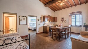 Una habitación acogedora con cama, techo de madera, zona de cocina y ventana.