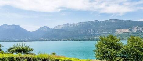 Una vista tranquila de un lago, con montañas al fondo y un cielo despejado.