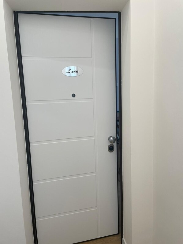 Une porte blanche avec une plaque portant le nom « Luna » et un trou de serrure.