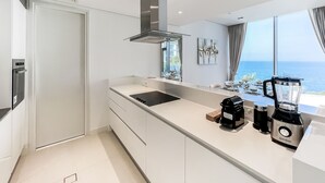 A modern kitchen with a large island, a built-in oven, and a view of the sea. - Bluewaters Residences Building 5 Dubai (Dubai)