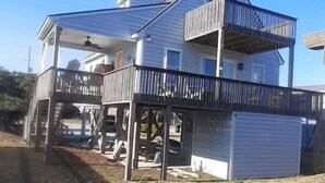 Une maison à deux étages avec un balcon au dernier étage.