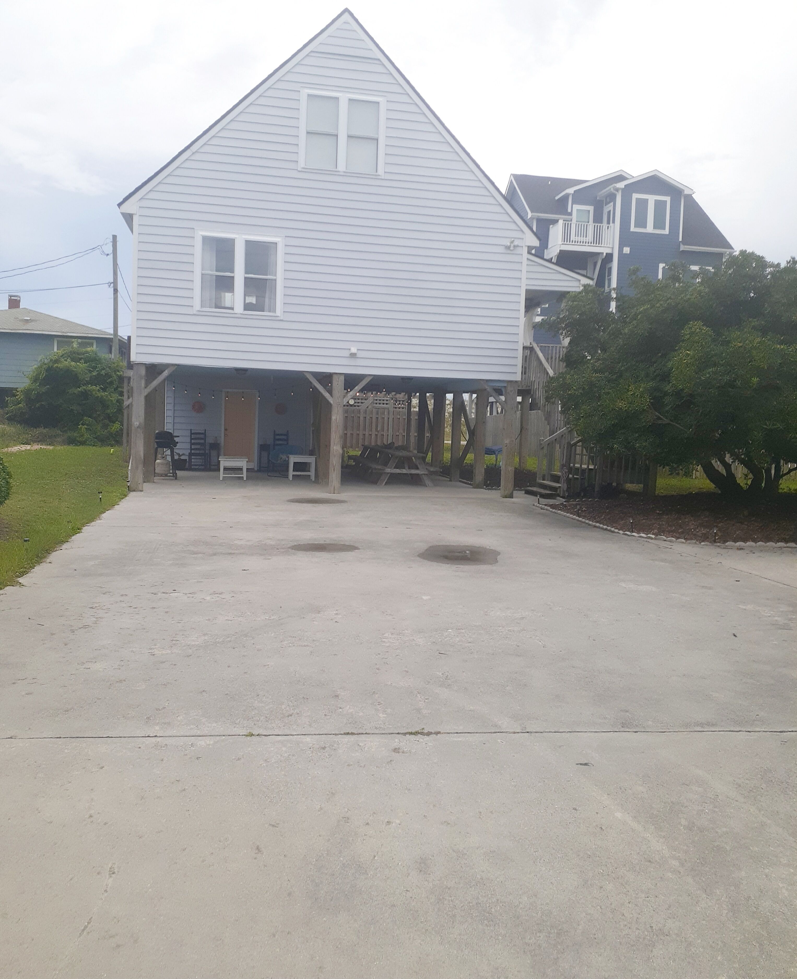 A two-story house with a covered porch and a driveway.