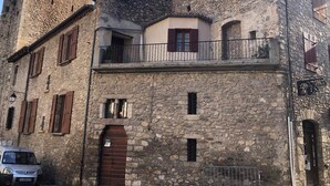 A stone building with a balcony, a door, and a small window. - Agréable Maison en Pierre Avec Terrasse, au Coeur de la Citadelle (Villefranche-de-Conflent)