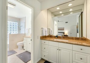 A modern bathroom with a large mirror, white cabinets, and a beige countertop. - Palm Springs Pool and Golf Oasis - Stunning Views & Private Pool in Palm Springs (Palm Springs)