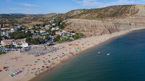 A coastal town with a beach, houses, and cliffs.