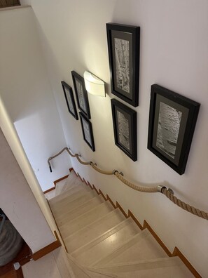 A staircase with a handrail and a rope barrier.