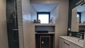 A modern bathroom with a shower, a sink, and a mirror. - Audrey and Etienne's (Présailles)