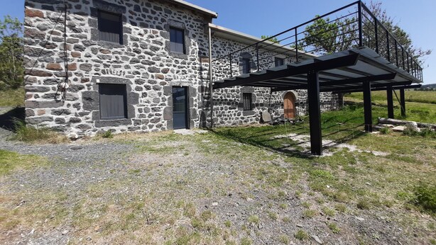A stone building with a covered outdoor area and a small arched window. - Audrey and Etienne's (Présailles)