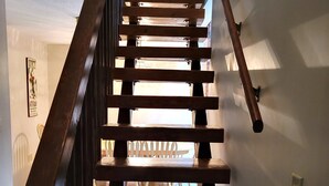 A wooden staircase with a handrail, leading to an upper floor.