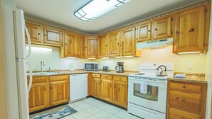 A kitchen with wooden cabinets, a microwave, a stove, and a dishwasher.