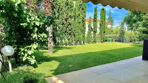 A well-maintained backyard with a lawn, a pergola, and a tall tree. - Panorama Hills Villa (Pylaia-Chortiatis)
