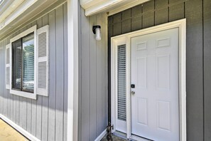 A house with a white front door and shutters, a small porch, and a mailbox.