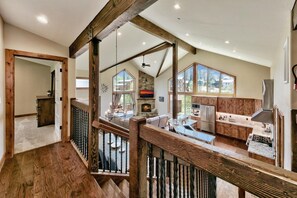 A spacious kitchen with wooden cabinets, a stone fireplace, and large windows. - Make Memories Together in This Spacious 5BR Tahoe Retreat - Enjoy Built-In Midweek Savings! (South Lake Tahoe)