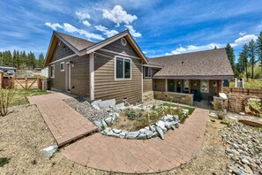 A two-story house with a covered patio and a stone pathway leading to the entrance. - Make Memories Together in This Spacious 5BR Tahoe Retreat - Enjoy Built-In Midweek Savings! (South Lake Tahoe)