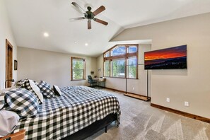 A bedroom with a bed, a desk, and a painting on the wall. - Make Memories Together in This Spacious 5BR Tahoe Retreat - Enjoy Built-In Midweek Savings! (South Lake Tahoe)