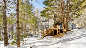 A cabin with a wooden deck and a staircase leading to a second level. - Boone Hideaway w/ Deck, Grill & Hot Tub! (Boone)
