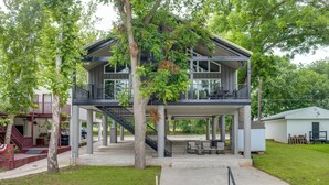 Edifici de dues plantes amb un balcó, una escala i una zona d'estar exterior coberta.