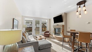 A modern living room with a sofa, coffee table, and dining area.