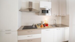 A modern kitchen with white cabinets, a stainless steel microwave, a gas stove, and a sink. - Convenient for motorway (Però exit) and for those using public transport ( Però) (Pero)