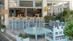 A cafe with a bar area, seating, and potted plants. - Samaria by the Sea (Sfakia)