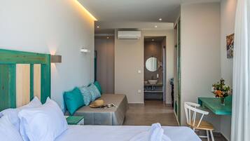 Ein Hotelzimmer mit zwei Betten, einem Schreibtisch, einem Stuhl, einem Badezimmer und einer kleinen Sitzecke.