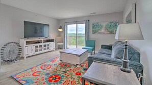 A living room with a TV, sofa, coffee table, and a patterned rug. - Cozy Family Condo w/ Balcony in Heart of Branson (Branson)