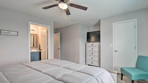 A bedroom with a bed, a ceiling fan, a television, a dresser, and a chair. - Cozy Family Condo w/ Balcony in Heart of Branson (Branson)