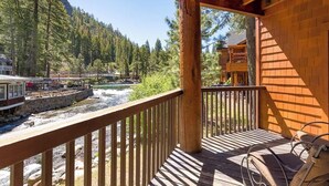 A wooden deck with a view of a river and forest. - Updated Condo with River Views! Near Alpine! (Alpine Meadows)