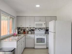 Enjoy cooking in this well-equipped kitchen with a microwave, stove, and refrigerator.