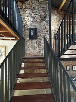 A staircase with stone walls and metal railings. - Château Les Poules - new bright modern and cosy loft  (ASSIGNAN)