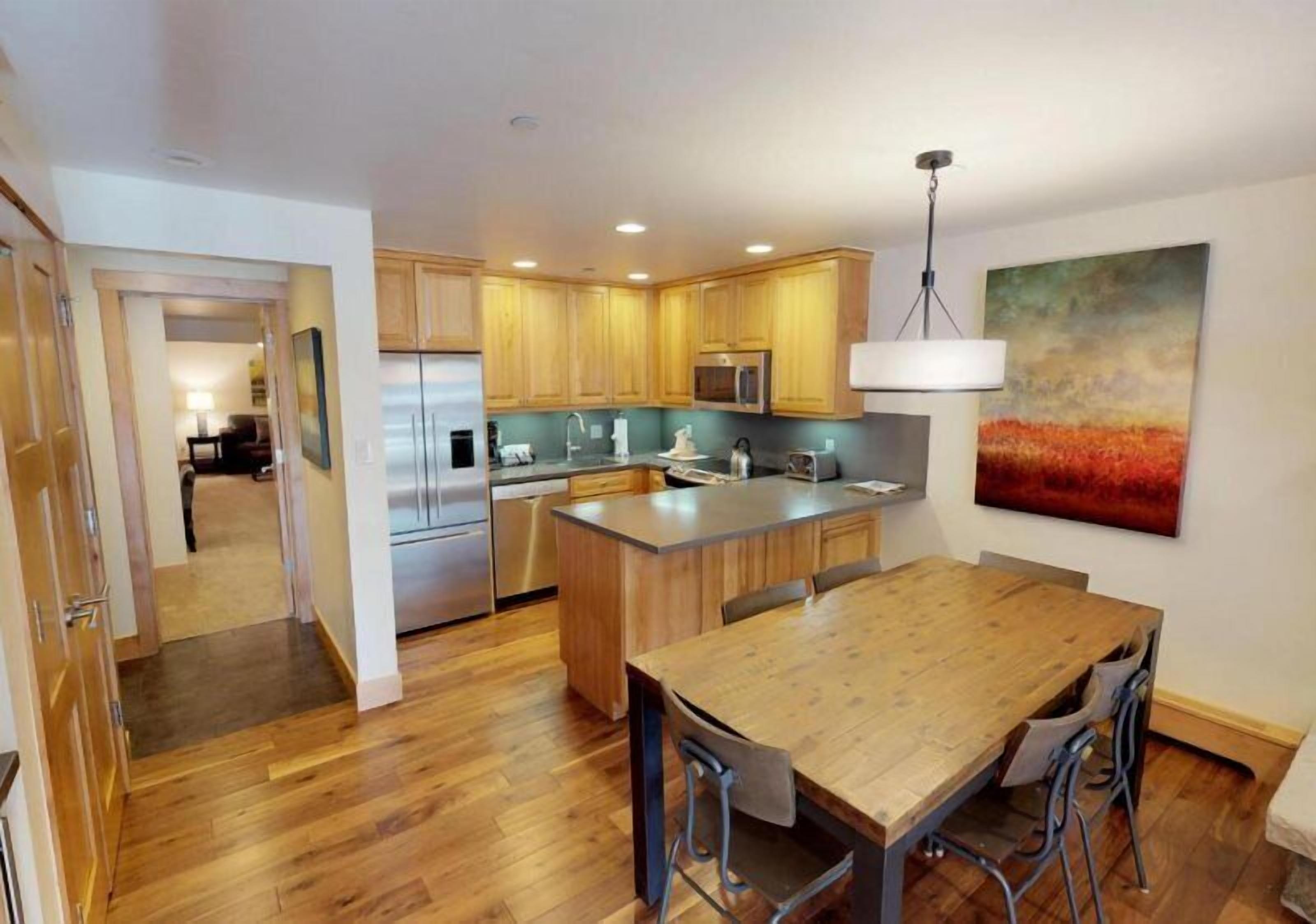 A modern kitchen with wooden cabinets, stainless steel appliances, and a central island.